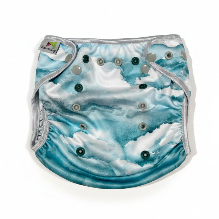 Stoffwindel-PUL-Überhose weiß mit grün-grauen Aquarell-Farbverläufen in Größe Onesize zugeknöpft in der größten Einstellung auf weißem Hintergrund.